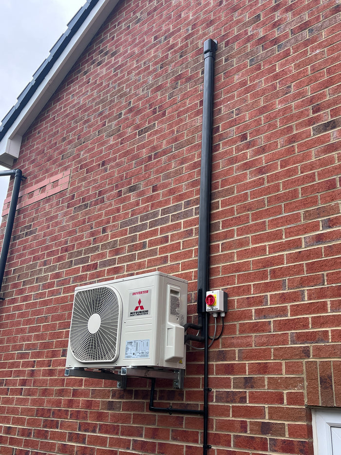 Mitsubishi outdoor condenser installed on wall brackets with black trunking