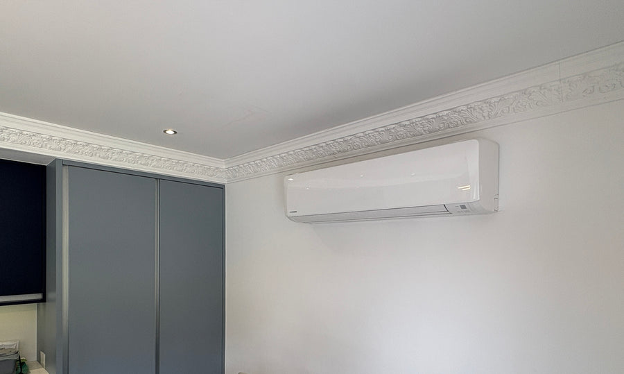 Finished wall mounted air conditioning unit installed neatly in a bedroom