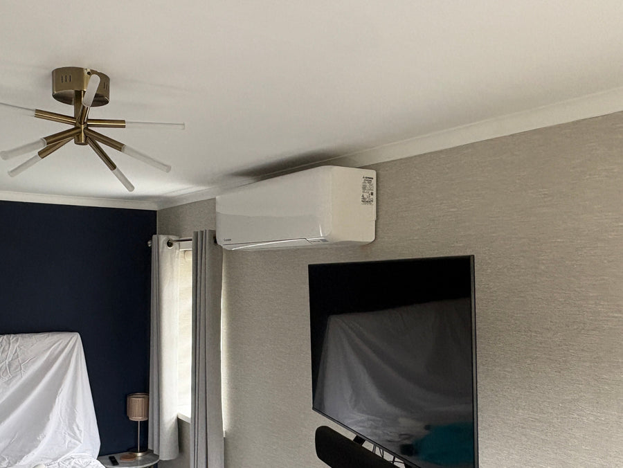 Wall mounted Mitsubishi air conditioning unit installed in a living room